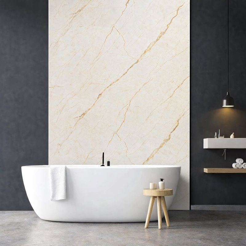 Panneau mural effet marbre beige clair veiné doré installé dans une salle de bain moderne avec baignoire îlot
