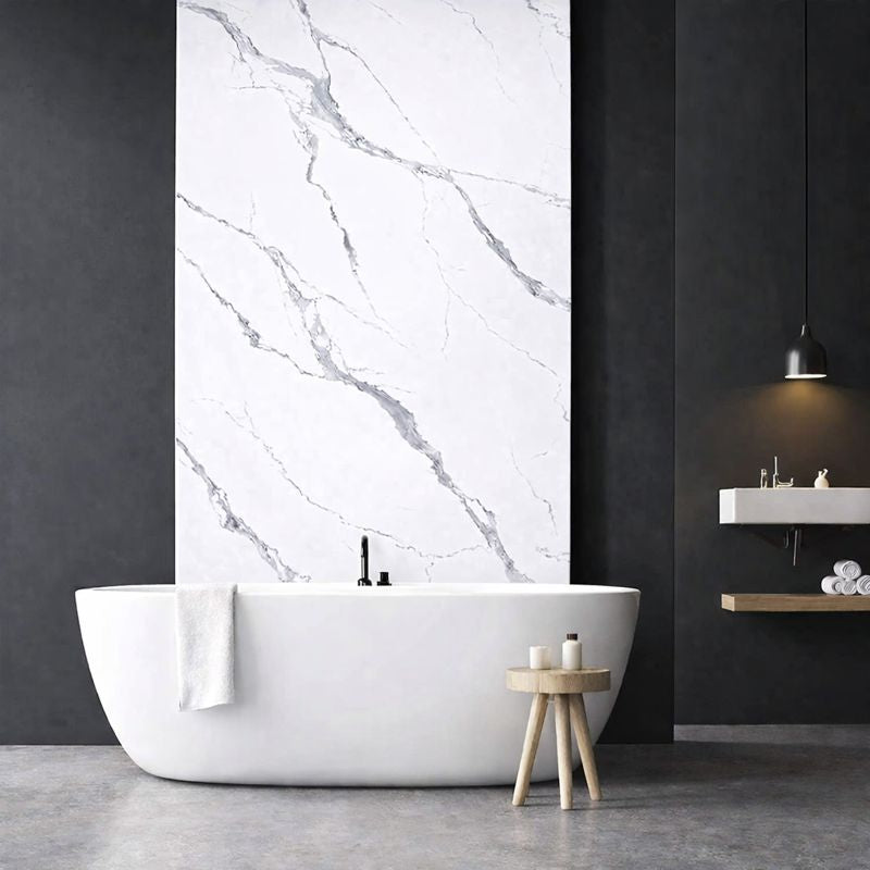 Panneau mural effet marbre blanc veiné gris installé dans une salle de bain moderne avec baignoire îlot