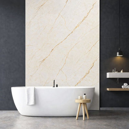 Panneau mural effet marbre beige clair veiné doré installé dans une salle de bain moderne avec baignoire îlot
