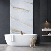 Panneau mural effet marbre blanc clair veiné or installé dans une salle de bain moderne avec baignoire îlot
