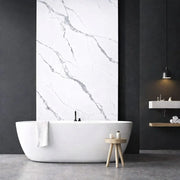 Panneau mural effet marbre blanc veiné gris installé dans une salle de bain moderne avec baignoire îlot
