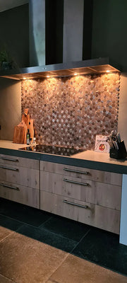 Crédence autocollante hexagone champagne et bronze posée sous une hotte avec éclairage intégré