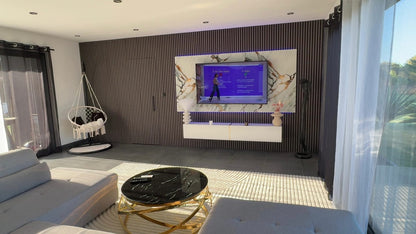 panneau pvc qatar doré posé derriere télé salon 